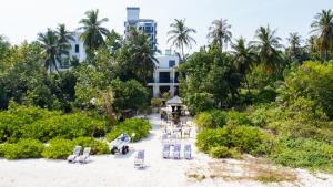 an aerial view of a beach with chairs and a building at Atoll Residence Dhangethi in Dhangethi