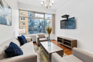 sala de estar con sofá y TV en National at 888 Sixth Avenue - Furnished Apartments, en Nueva York