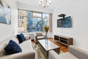 a living room with a couch and a tv at National at 888 Sixth Avenue - Furnished Apartments in New York