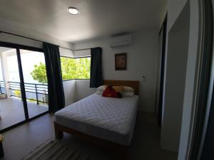 - une chambre avec un lit et une grande fenêtre dans l'établissement Villa MATOANUI, à Tevaitoa