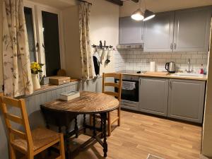 a kitchen with a table and chairs in a kitchen at The Barn at Providence Cottage in Alkborough