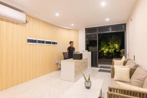 a man standing at a desk in an office at Atoll Residence Dhangethi in Dhangethi