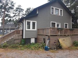 a house with a deck and a bike in front of it at Omakotitalo ykspihlajassa 110m2 in Kokkola