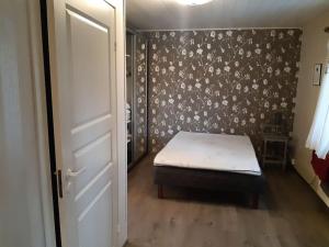 a bedroom with a bed with a floral wallpaper at Omakotitalo ykspihlajassa 110m2 in Kokkola