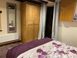 a bedroom with a bed and a wooden cabinet at The Barn at Providence Cottage in Alkborough