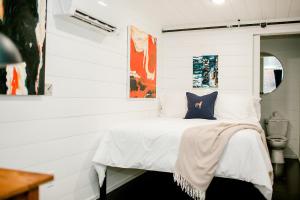 Dormitorio blanco con cama con almohada azul en The Middleton Hotel, en Graham