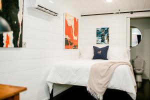 a white bedroom with a bed with a blue pillow at The Middleton Hotel in Graham