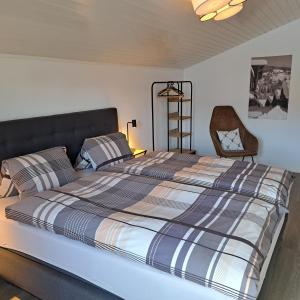 a bedroom with a large bed and a chair at B&B Pension Rustica in Inden