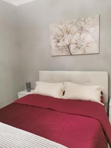 1 dormitorio con 1 cama con manta roja en Splendido appartamento in zona centrale, en Alessandria