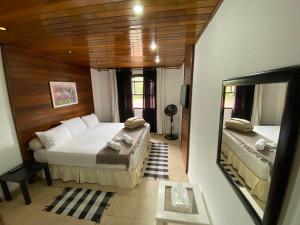 a bedroom with two beds and a large mirror at Casa Colona - Guesthouse in Petrópolis +42 photos