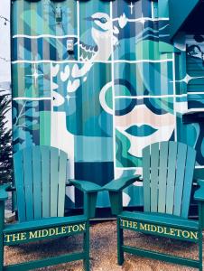 two chairs sitting in front of a mural at The Middleton Hotel in Graham