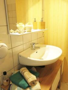 een badkamer met een witte wastafel en een spiegel bij Stuckverzierte, zentrumsnahe Wohnung im Süden in Leipzig