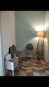 een kamer met 2 stoelen, een tafel en een lamp bij Stuckverzierte, zentrumsnahe Wohnung im Süden in Leipzig