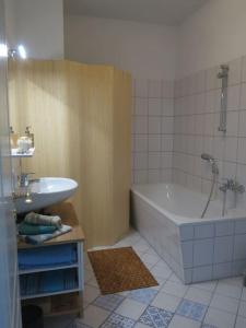een badkamer met een bad en een wastafel bij Stuckverzierte, zentrumsnahe Wohnung im Süden in Leipzig