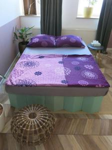 een bed met een paarse deken erop bij Stuckverzierte, zentrumsnahe Wohnung im Süden in Leipzig