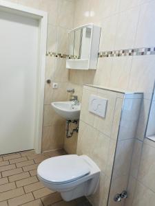 a bathroom with a toilet and a sink at M&M Hotel - Wilhelmsburg in Hamburg