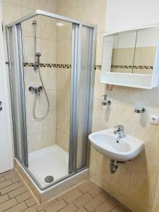 a bathroom with a shower and a sink at M&M Hotel - Wilhelmsburg in Hamburg