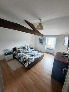 1 dormitorio con 1 cama y suelo de madera en Maison chaleureuse avec jardinet & parking gratuit, en Eymet