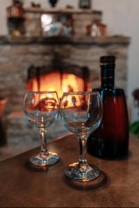 two wine glasses sitting on a table with a fireplace at Lazaros Stonehouse in Pano Lefkara