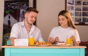 a man and woman sitting at a table with a plate of food at Hotel Reventazón Orosi in Orosí