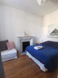 ein Schlafzimmer mit einem Bett und einem Sofa in der Unterkunft Appartement dans une villa au cœur de la ville in Barcelonnette