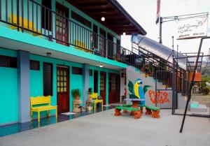 a colorful building with a bench and a train at Hotel Reventazón Orosi in Orosí