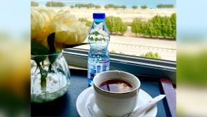 un tavolo con una tazza di caffè e una bottiglia d'acqua di Diamond Tower ad Al Jubail