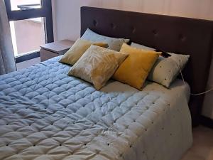 1 cama con almohadas en el dormitorio en Cozy holiday home in a charming area, en Montilla