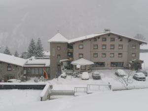 a large building with snow on top of it at Hotel Rotlechhof in Berwang