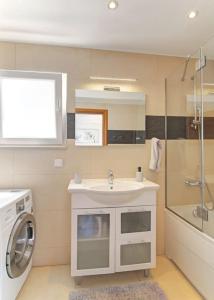 a bathroom with a sink and a washing machine at Seaside Apartment M Zaton 5 - Sea View & Parking in Zaton