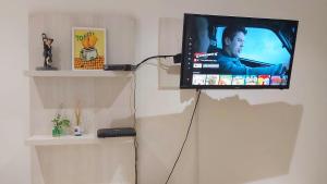 TV de pantalla plana colgada en la pared en Abrazo Fueguino: calido comodo y centrico -WiFi en Ushuaia