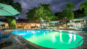 una gran piscina por la noche con luces en Jarabacoa River Club & Resort en Jarabacoa