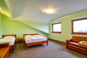a room with two beds and a couch in it at Hotel Tenis in Chrząstowice
