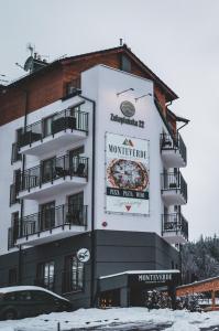 a large white building with a pizza sign on it at Apartamenty MonteVerde w Świeradowie-Zdroju in Świeradów-Zdrój
