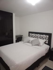 1 dormitorio con 1 cama grande con sábanas blancas en V&B Apartamento, en Bogotá