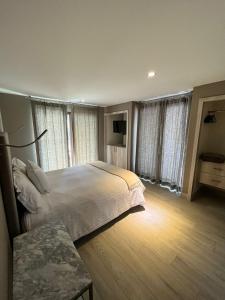 1 dormitorio con 1 cama grande y algunas ventanas en Suites Casa Mateo San Miguel Allende, en San Miguel de Allende