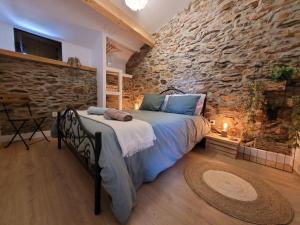 a bedroom with a bed in a stone wall at Casa da Memória in Milhão
