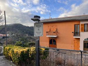 a sign on a pole in front of a building at Hotel Meri 1956 Locanda e Cucina in Framura