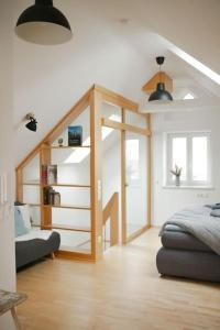 a living room with a bed and a stair case at Stilvolles kleines Ferienhaus mit Garten 