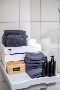 a shelf with towels and towels on it in a bathroom at Stilvolles kleines Ferienhaus mit Garten 