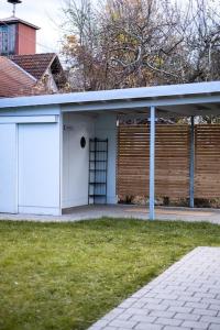 een huis met een witte garage met een hek bij Stilvolles kleines Ferienhaus mit Garten 