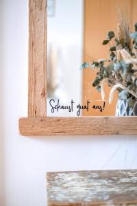 a mirror with a sign in front of a plant at Stilvolles kleines Ferienhaus mit Garten 