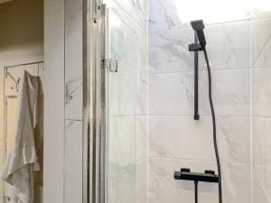bagno con doccia e pareti in marmo bianco di Alt-na-craig a Rothbury