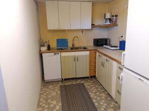 a small kitchen with white cabinets and a sink at Ett rums lägenhet med egen ingång, parkering in Örebro