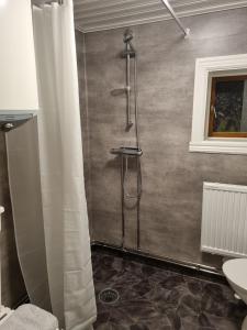 La salle de bains est pourvue d'une douche avec rideau de douche. dans l'établissement Lillastugan Sätuna, à Falköping