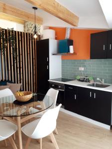 a kitchen with a glass table and white chairs at Casa da Memória in Milhão