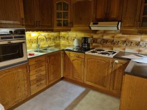 a kitchen with wooden cabinets and a stove top oven at Lillastugan Sätuna in Falköping