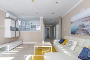 uma sala de estar com um sofá branco e uma mesa de centro em Apartamento con sol de paz em Torremolinos