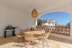 een patio met een tafel en stoelen en een grill bij Luxury Villa Andalucia Seaview Private Pool close to Centre in Benalmádena