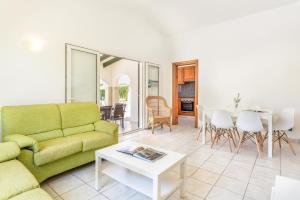 a living room with a green couch and a table at Villa Luna by Villa Plus in Cala'n Bosch